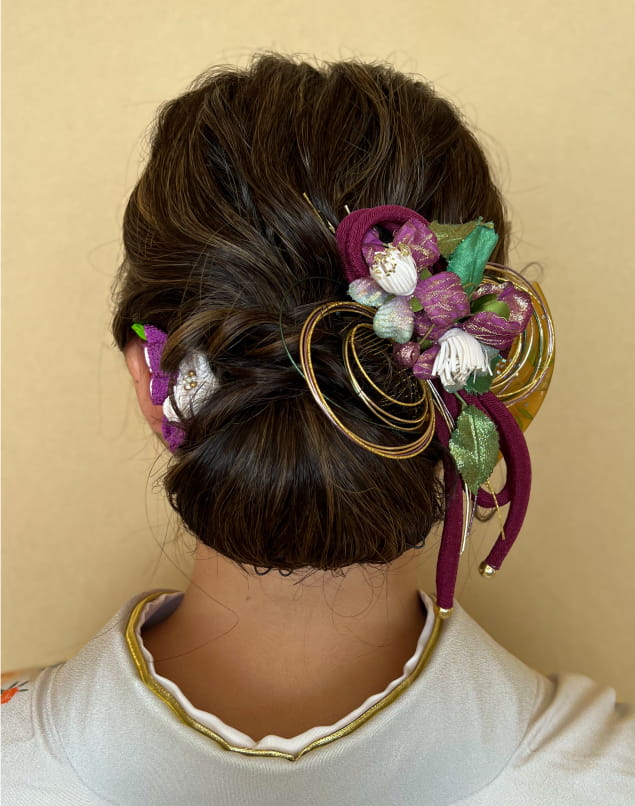 華やかな髪飾りを使ったロングヘアのアップスタイル